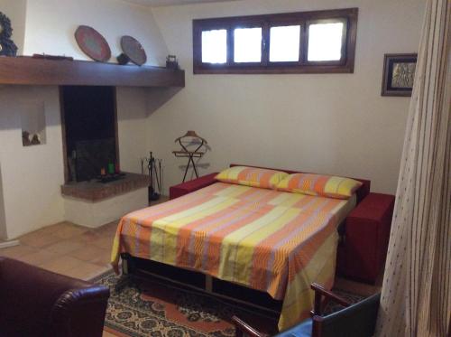 1 dormitorio con 1 cama, chimenea y ventana en Taverna Grika, en Lecce