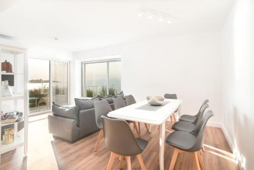 a living room with a white table and chairs at Epipleon suites in Áyioi Apóstoloi