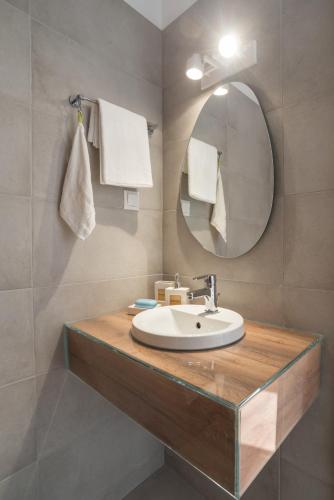 a bathroom with a sink and a mirror at Epipleon suites in Áyioi Apóstoloi