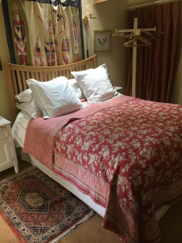 - un lit avec une couverture rouge et des oreillers blancs dans l'établissement The old forge bed and breakfast, à Dorchester