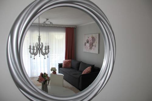 a living room with a couch and a mirror at Apartment Snježana in Slunj