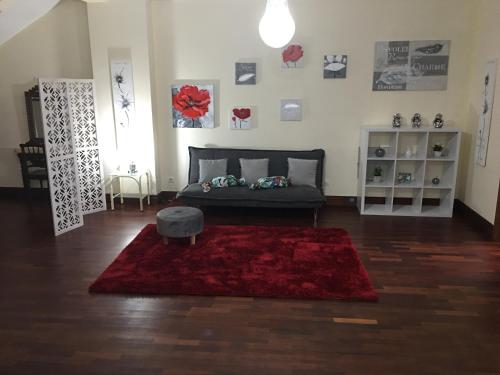 a living room with a couch and a red rug at Casa do Largo in Furnas