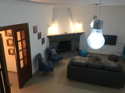 a living room with a couch and a fireplace at Casa do Largo in Furnas