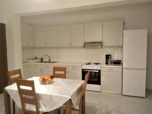 Grammatoula Apartment في نِكيانا: مطبخ مع طاولة وثلاجة بيضاء