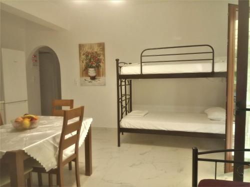 Grammatoula Apartment في نِكيانا: غرفة طعام مع سريرين بطابقين وطاولة مع طاولة بلياردو