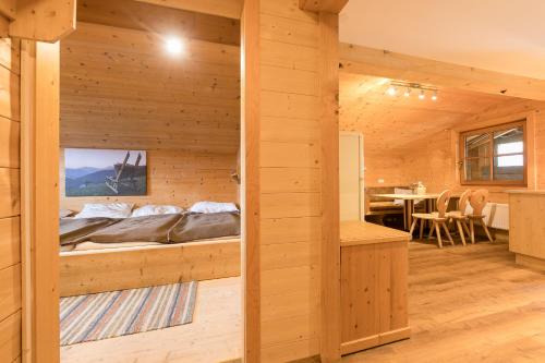 a bedroom in a log cabin with a bed at Balbach Alm Apartment in Oetz