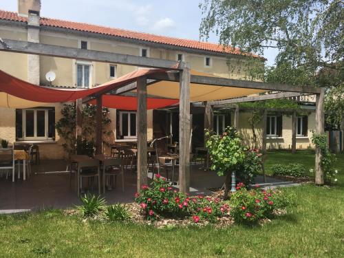 a garden with a pergola in front of a building at Hotel du parc in Vergt