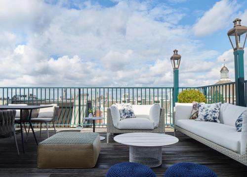 a patio with two couches and a table on a deck at Kimpton De Witt Amsterdam, an IHG Hotel in Amsterdam