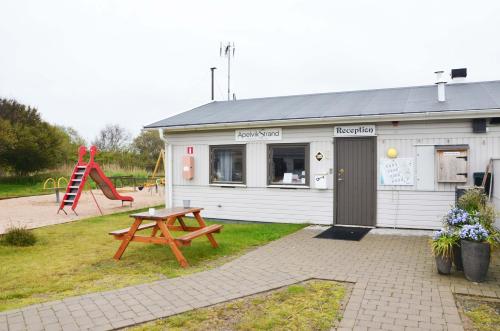 a building with a picnic table and a playground at Apelvikstrand in Varberg