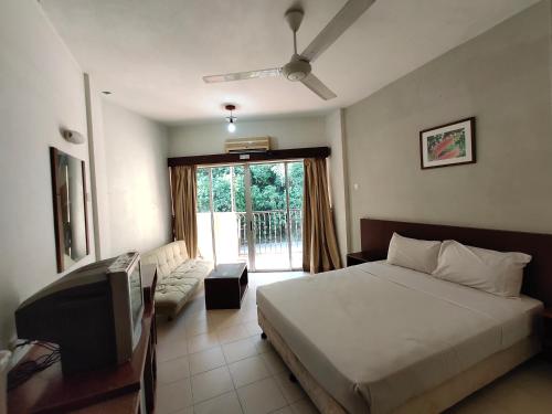 1 dormitorio con 1 cama, TV y ventana en Jana View Condotel MN, en Kamunting