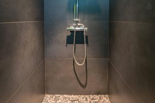 uma casa de banho com um chuveiro e uma mangueira na parede em Chambre d'hôtes LE SECADOU em La Ciotat