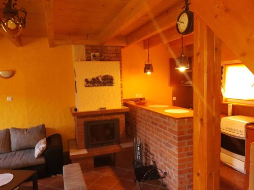 a living room with a fireplace and a kitchen at Domek nad jeziorem, Kalinówka w Olchowcu, Solina in Olchowiec