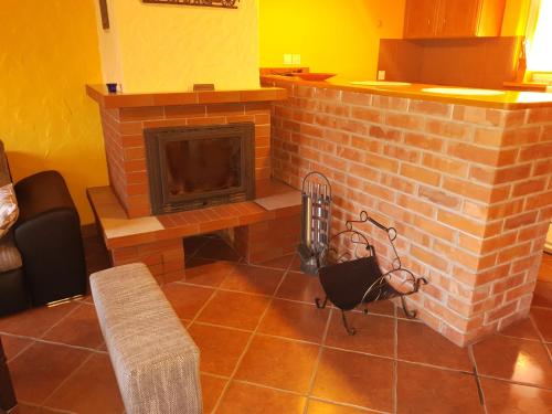 a living room with a brick fireplace in a room at Domek nad jeziorem, Kalinówka w Olchowcu, Solina in Olchowiec