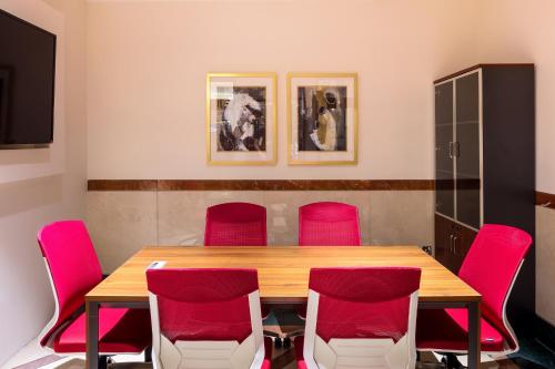 a conference room with a wooden table and red chairs at Coral Dubai Deira Hotel in Dubai