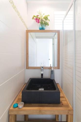 a bathroom with a sink and a mirror at Villa "Doucè Kréyol" in Le Marin