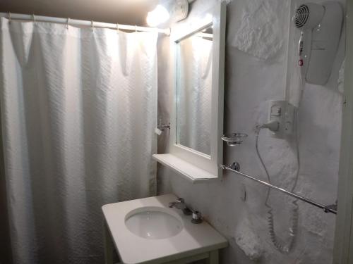 y baño con ducha, lavabo y espejo. en Cabañas El Refugio del Atuel en San Rafael