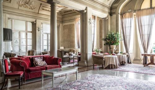 un soggiorno con divano rosso e tavolo di Bagni Di Pisa Palace & Thermal Spa - The Leading Hotels of the World a San Giuliano Terme