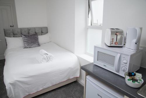 a small bedroom with a bed and a tv at TLK Apartments & Hotel - Beckenham in Beckenham