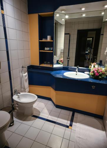 a bathroom with a sink and a toilet and a mirror at Juffair Grand Hotel in Manama