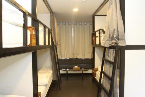 a room with three bunk beds and a table at Hamra Urban Gardens in Beirut