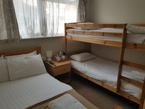 a bedroom with two bunk beds and a window at Victoria Lodge in Shanklin
