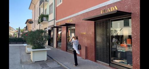 a woman is standing outside of a store window at Exclusive Loft 300mt by the sea Forte dei Marmi in Forte dei Marmi