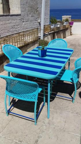 a blue table and chairs with the ocean in the background at Il Mulino di Amleto - Bed and Breakfast letterario in Molfetta
