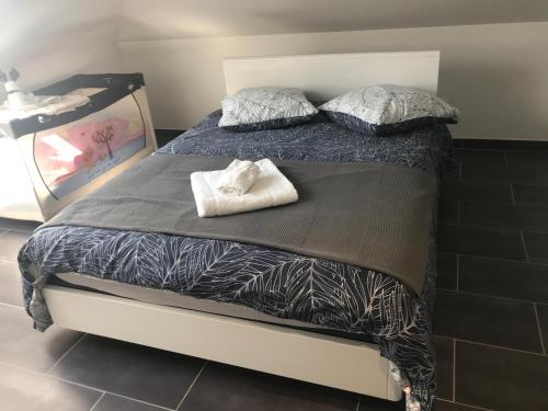a bed with two pillows on top of it at Appartement standing à Valmont in Macheren