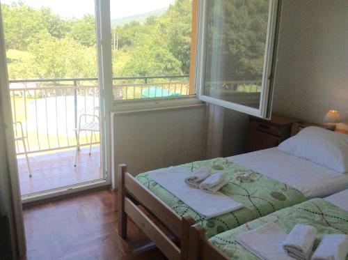 sypialnia z 2 łóżkami i balkonem z widokiem w obiekcie Apartman Katica w mieście Plomin
