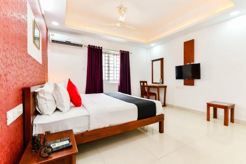 a hotel room with a bed and a tv at Hotel Hilite Inn in Cochin