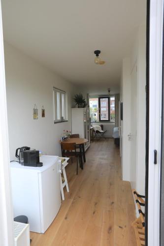 a kitchen and dining room with a table and refrigerator at B&B De Zwanebloem in Amsterdam