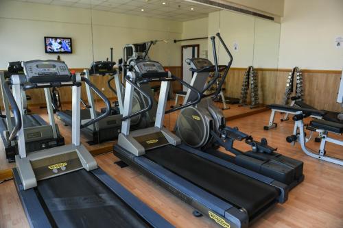 a gym with treadmills and ellipticals in a room at Juffair Grand Hotel in Manama