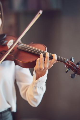 a woman playing a violin with her hands at Ramada Plaza By Wyndham Istanbul City Center in Istanbul