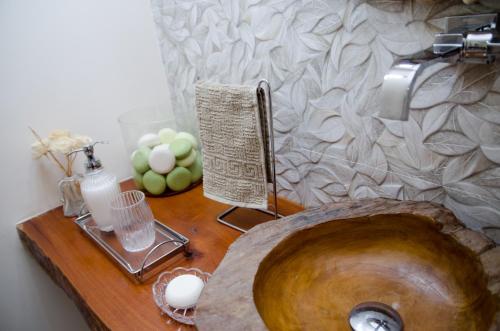 a bathroom with a wooden sink and a wooden table at Hotel Pousada La Belle in Itaguaí