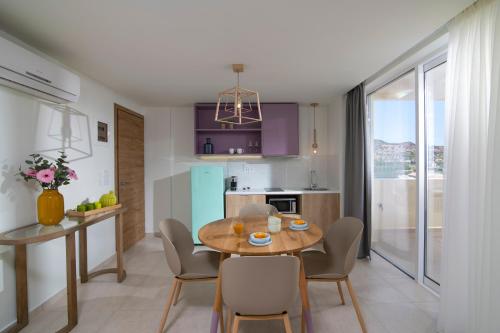 a kitchen and dining room with a table and chairs at Rainbow Apartments in Stalida