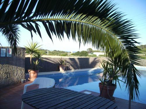 a table and a chair next to a swimming pool at Agroturisme s' Horta in Capdepera