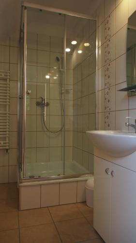 グダニスクにあるWyspiarze - Apartament Wyspa Sobieszewskaのバスルーム(シャワー、バスタブ、シンク付)