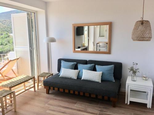 a living room with a blue couch and a mirror at Ses Terrasses in Cadaqués
