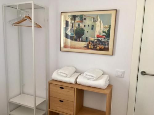 a bathroom with two towels on a wooden table at Ses Terrasses in Cadaqués