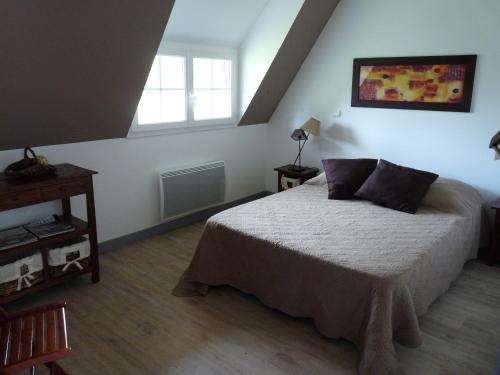 a bedroom with a bed and a window at LA CHAUMIERE in Saint-Léger-de-Rotes