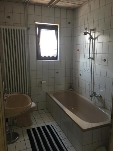 a bathroom with a tub and a sink and a window at Ferienwohnung Rhön in Bastheim