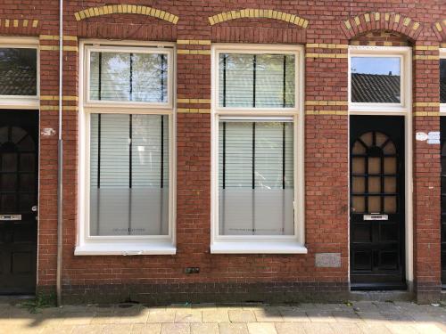 a brick building with two windows and two doors at Butterfly in Groningen