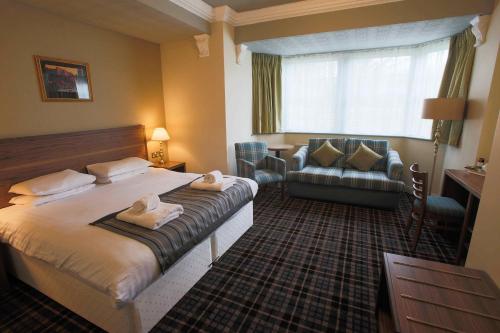 a hotel room with a bed and a living room at The Bamburgh Castle Inn - The Inn Collection Group in Seahouses