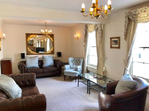 een woonkamer met een bank, stoelen en een spiegel bij Lauras Townhouse Apartments Lansdown Slope Townhouse in Bath