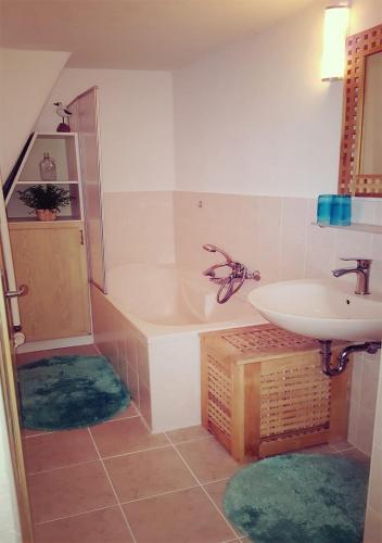 a bathroom with a sink and a bath tub and a sink at Ferienhaus Polly - Keine Monteure in Rabenau