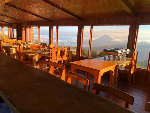 a restaurant with tables and chairs with a view of a mountain at Vistaverde Lodge in Monteverde Costa Rica
