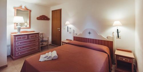 Residence Hotel Nuraghe في بورتو روتوندو: غرفة في الفندق سرير عليه حذاء