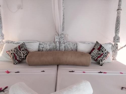 a white couch with pillows on top of it at Aquarius Club in Watamu