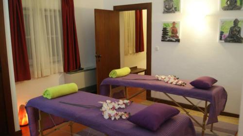 two purple beds in a room with flowers on them at Hotel Rural Quinta de Santo Antonio in Elvas