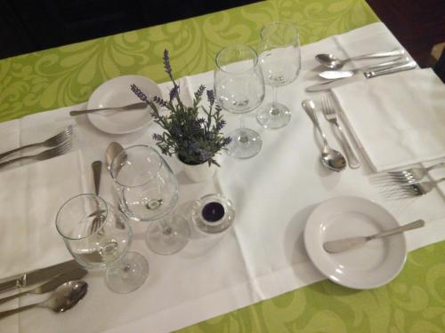 a table with a white table cloth with glasses on it at Hotel Rural Quinta de Santo Antonio in Elvas